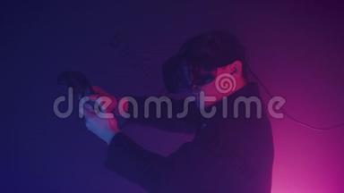 虚拟现实中的年轻帅哥在网上射击游戏中使用控制器射击网络霓虹灯